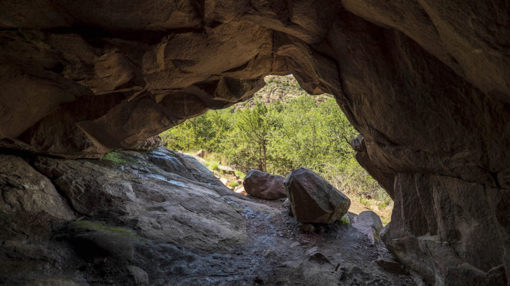 A photograph taken by Dennis Spielman of inside a small cave during the day at Quartz Mountain. 