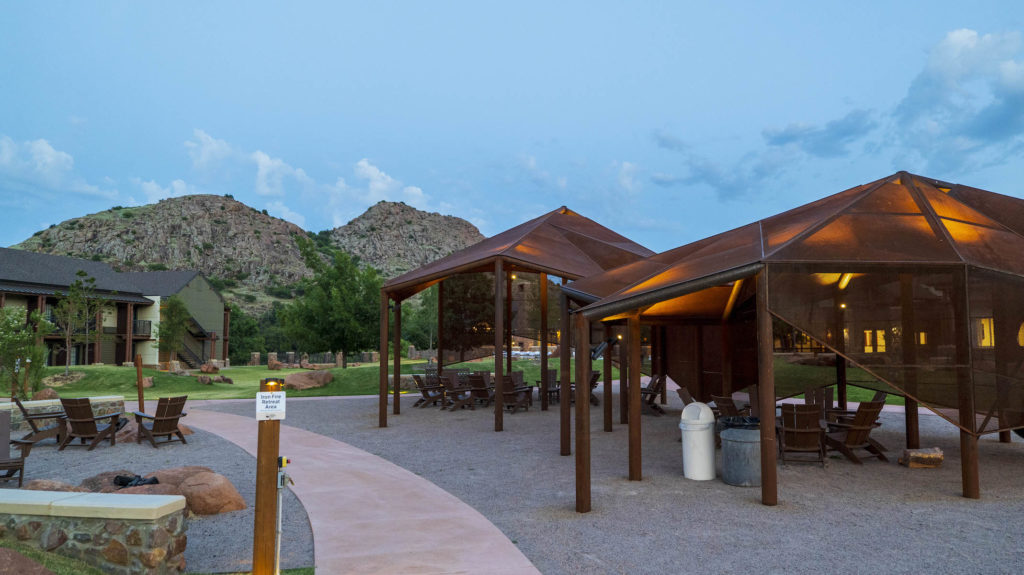 A photograph taken by Dennis Spielman of artistic metal gazebos in a courtyard designed to mirror the twin peaks mountains seen in the background.