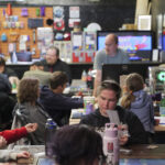 People gathered around for gaming night in a D&D lounge