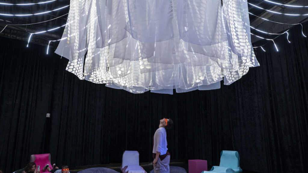 Photo by Dennis Spielman of a person standing looking inside the star at the Cosmic Callback experience.